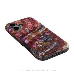 May include: A smartphone case featuring a mosaic pattern of iridescent, multi-colored tiles in shades of deep red, magenta, and brown. The design includes shimmering blue and gold accents, with cutouts for the camera lens and charging port.
