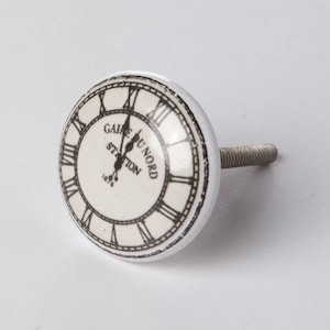May include: White ceramic knob with a black and white clock face design. The clock face reads "Gare du Nord Station 1875".