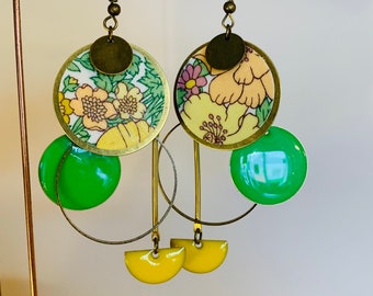 Könnte beinhalten: Ein Paar goldfarbene Ohrringe mit grünen und gelben Emaille-Akzenten. Die Ohrringe haben ein florales Muster und ein kreisförmiges Design.