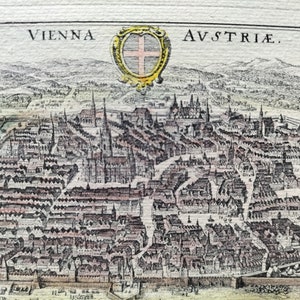Pode incluir: Um mapa antigo de Viena, Áustria, com o nome da cidade e "AVSTRIAE" escrito no canto superior direito. O mapa mostra uma visão detalhada das ruas e edifícios da cidade, com um brasão que apresenta uma cruz no centro.