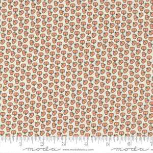 May include: A cream-colored fabric with a repeating pattern of small orange pumpkins. The fabric is marked with a ruler in inches and the text "moda" appears on the left and right sides of the ruler.