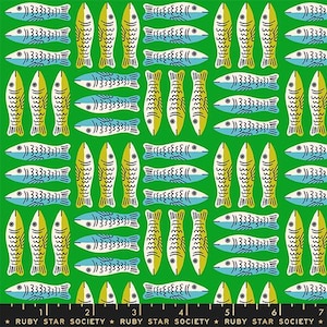 May include: A green fabric featuring a repeating pattern of stylized fish in light blue and yellow. The fish are arranged in alternating horizontal and vertical groups. A black ruler with white markings and the text Ruby Star Society is visible.