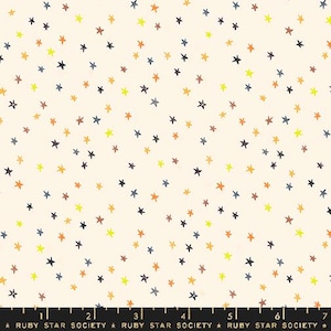 May include: A white fabric with a repeating pattern of small, hand-drawn stars in various shades of yellow, orange, brown, and blue.