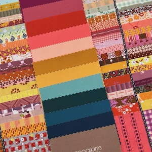 May include: A collection of fabric strips featuring a wide variety of patterns including floral, geometric, and plaid designs in shades of red, orange, yellow, teal, and brown. A central stack of solid-colored fabric strips with pinked edges.