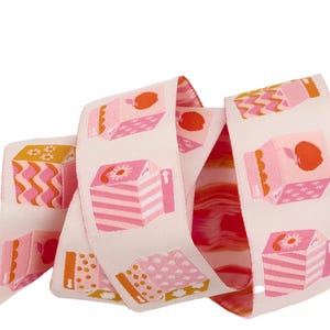 May include: Pink and orange ribbon with a repeating pattern of juice boxes with apples on a white background.
