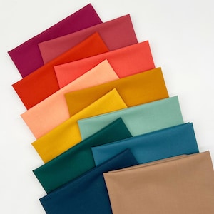 May include: A collection of rectangular fabric swatches arranged in a fan-like pattern. The colors include shades of magenta, red, orange, peach, yellow, mustard, mint green, teal, dark blue, and a solid tan square at the bottom right.