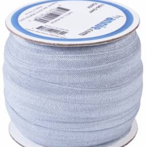 May include: A spool of light blue elastic ribbon. The ribbon is wound around a white cardboard spool with the text "Adorne Craft" printed in blue.