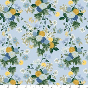May include: Floral fabric with a light blue background. The design features clusters of yellow, blue, and white flowers with green leaves and stems. The text "COTTON + STEEL" and "We make pretty fabrics" is visible.