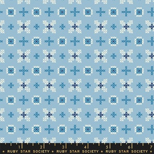 May include: A blue and white cross stitch pattern fabric with a repeating design of squares and crosses. The fabric is from Ruby Star Society.