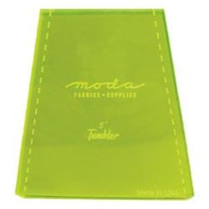 May include: A green 5" Tumbler acrylic quilting ruler with the text "moda fabric supplier" and "Made in USA".