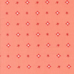 May include: Coral-colored fabric with a repeating pattern of red four-petal flower shapes with white centers and red asterisk shapes. The fabric has a slightly textured appearance.
