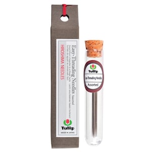 May include: A package of assorted easy-threading needles from Hiroshima Needles. The needles are in a clear glass tube with a cork stopper. The tube is next to a brown cardboard box with the brand name and product information printed on it.