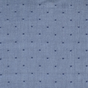 May include: A close-up of a blue fabric with a repeating pattern of small, dark blue squares. The fabric has a slightly textured appearance, and the squares are evenly spaced across the surface.