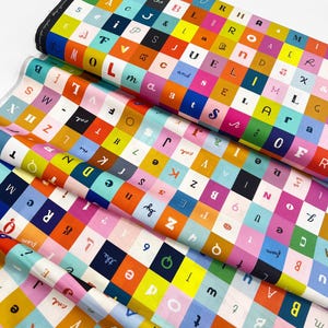 May include: Colorful fabric with a checkerboard pattern of letters, numbers, and symbols in various colors. The fabric is folded, showing multiple layers of the design. The text "the" and "and" are visible. This fabric is suitable for quilting and crafting.