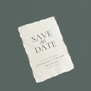 May include: A rectangular, off-white 'Save the Date' card with a torn edge. The text 'SAVE the DATE' is in a bold, elegant font. Below, it reads 'to celebrate the wedding of HANNAH & XAVIER FEB 11TH, 2030 invitation to follow'.