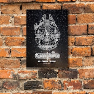 May include: A black and white schematic of the Millennium Falcon starship, with the text "MILLENNIUM FALCON" at the bottom. The artwork is displayed on a black background with a starry effect. The print is mounted on a weathered brick wall.