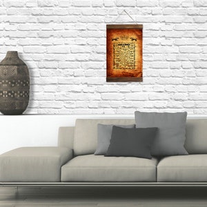 Puede incluir: Una impresi&oacute;n de estilo vintage con una inscripci&oacute;n en hebreo y un dise&ntilde;o de menor&aacute;. La impresi&oacute;n est&aacute; enmarcada en un marco de madera oscura y cuelga de una pared de ladrillo blanco.