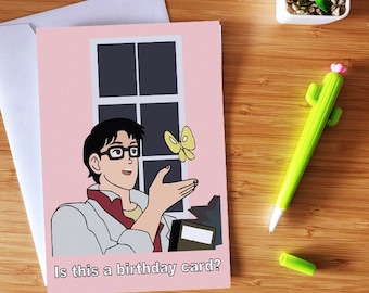 May include: A pink birthday card with a cartoon illustration of a person with glasses and a butterfly. The text on the card reads "Is this a birthday card?"
