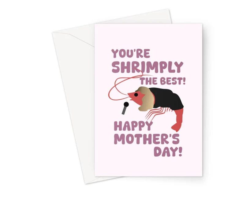May include: A pink greeting card with the text "You're Shrimply the Best! Happy Mother's Day!" and a cartoon shrimp wearing a black jacket and holding a microphone.