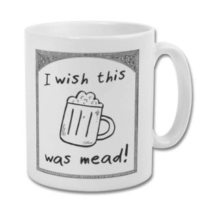 May include: White ceramic mug with a black and white illustration of a beer mug and the text "I wish this was mead!". The mug has a curved handle and a decorative border around the illustration.