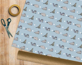 May include: Light blue wrapping paper with a repeating pattern of cartoon seals in various poses and white polka dots. A roll of brown paper, scissors, and tape are visible.