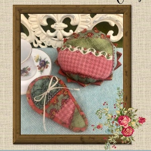May include: A framed image of a red and green patchwork pincushion and a red and green patchwork scissor case. The image is titled "Crazy Patch Pincushion and Scissor Case" and is from "Flatland Creations".