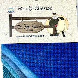 May include: A pack of blue and teal wool fabric scraps with a label that reads "Wooly Charms" and "In The Patch Designs" with a cartoon sheep and owl graphic.  www.inthepatchdesigns.com