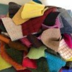 May include: A collection of colorful fabric scraps in various textures and patterns, including wool, felt, and tweed. The scraps are in shades of red, green, blue, yellow, purple, and brown.