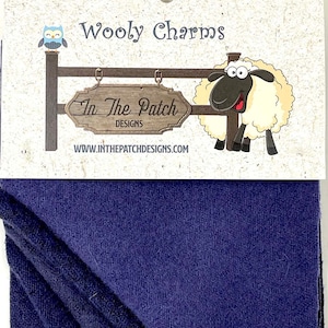 May include: A package of dark blue wool fabric with the text "Wooly Charms" and "In The Patch Designs" on the front. The package also features a cartoon sheep and owl.