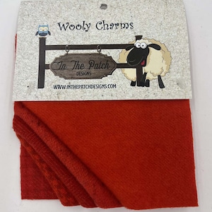May include: A red piece of wool fabric with a label that says "Wooly Charms" and "In The Patch Designs" with a cartoon sheep and owl.