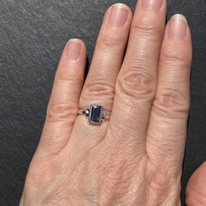 Peut inclure: Une bague en argent avec une pierre précieuse rectangulaire violette.