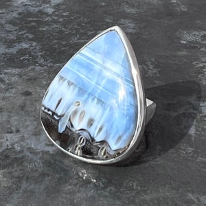 May include: A teardrop-shaped ring with a blue and white agate stone set in sterling silver.