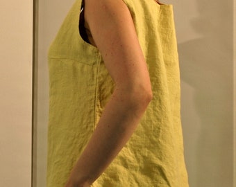 May include: A sleeveless, yellow linen top with a scoop neck. The top is loose fitting and has a relaxed silhouette.