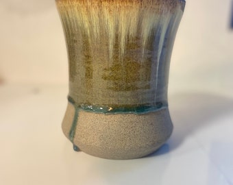 May include: A brown ceramic mug with a light yellow glaze and a blue glaze around the bottom.