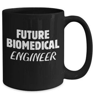 Könnte beinhalten: Schwarze Keramik-Kaffeetasse mit weißem Text, der "FUTURE BIOMEDICAL ENGINEER" lautet.