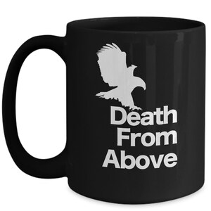 以下が含まれることがあります： 白い鷲のシルエットと「Death From Above」という文字が書かれた黒いセラミック製のコーヒーカップです。