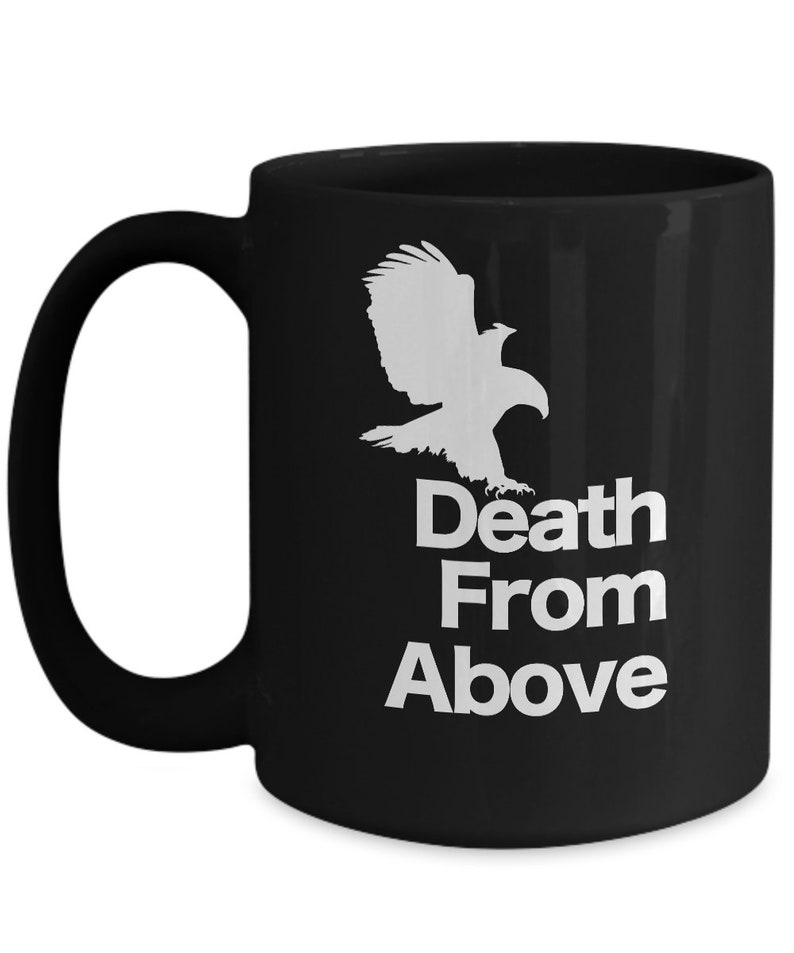 以下が含まれることがあります： 白い鷲のシルエットと「Death From Above」という文字が書かれた黒いセラミック製のコーヒーカップです。