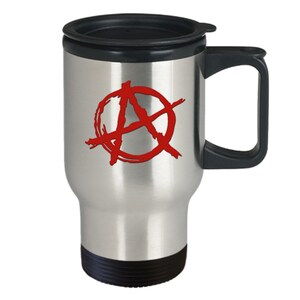 May include: A stainless steel travel mug with a black lid and handle. The mug has a red anarchy symbol printed on the front.