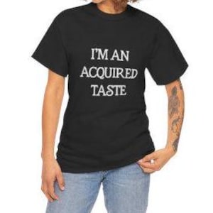 May include: Black t-shirt with white text that reads "I'm an acquired taste."