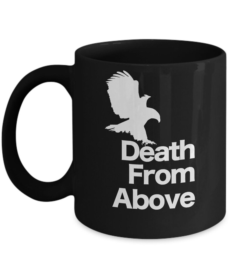 以下が含まれることがあります： 白い鷲のシルエットと「Death From Above」という文字が書かれた黒いコーヒーカップ。