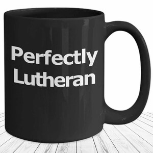 May include: Black coffee mug with white text that reads "Perfectly Lutheran".