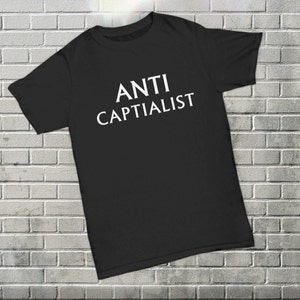 May include: Black t-shirt with white text that reads "ANTI CAPITALIST".
