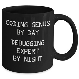 May include: Black coffee mug with white text that reads "Coding Genius By Day Debugging Expert By Night".