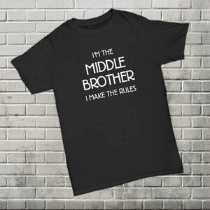 May include: Black t-shirt with white text that reads "I'm the middle brother I make the rules".