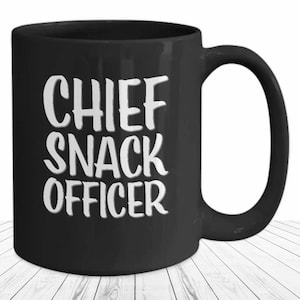 May include: Black ceramic coffee mug with white text that reads "Chief Snack Officer".