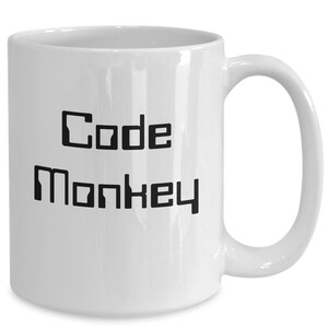 May include: White ceramic coffee mug with black text that reads "Code Monkey".