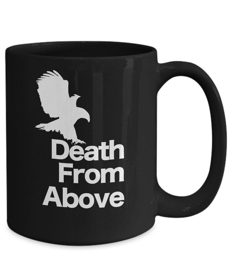 以下が含まれることがあります： 白い鷲のシルエットと「Death From Above」という文字が書かれた黒いセラミック製のコーヒーカップです。