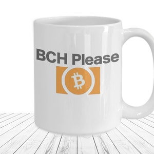 May include: White ceramic mug with a black and orange design. The mug says "BCH Please" with a Bitcoin symbol in the centre of an orange rectangle.