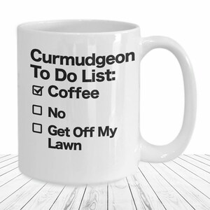 May include: White ceramic coffee mug with a black design that reads "Curmudgeon To Do List: Coffee, No, Get Off My Lawn".