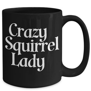 May include: Black coffee mug with white text that reads "Crazy Squirrel Lady".